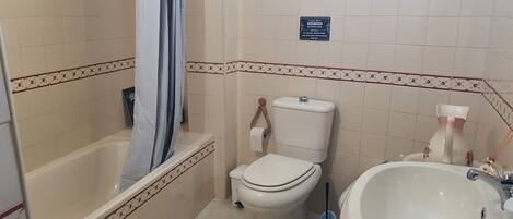 Une salle de bain avec une baignoire, des toilettes et un lavabo.
