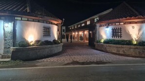 Un edificio con entrada empaveda y muros de piedra, iluminado por luces cálidas.