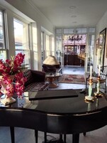 Amplia sala de estar con un gran ventanal, un sofá, una mesita de centro y un jarrón decorativo con flores.
