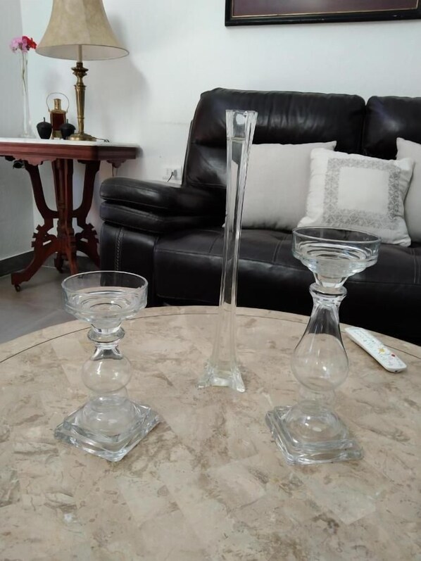 A marble table with three clear glass vases and a remote control. - Hotel Boutique Grand Cru (Santa Cruz)
