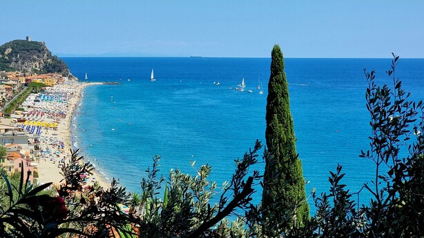 A coastal town with a beach, boats, and a prominent tree. - Holiday Home 'Il Carrubo' with Sea View, Wi-Fi and Air Conditioning (Finale Ligure)