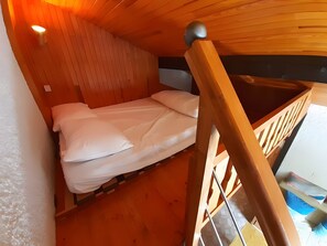 2 dormitorios y tabla de planchar con plancha