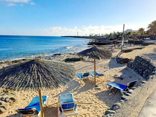 Coastal style villa blends in with its surroundings.  Pool view.