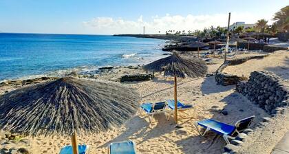 Coastal style villa blends in with its surroundings. Pool view.