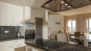 A modern kitchen with a built-in microwave, oven, and stainless steel range hood. - Villa 'Lirio' with Mountain Views, Wi-Fi, and Air Conditioning (Benalup-Casas Viejas)