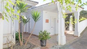 A covered patio area with a white wall, a door, and a potted plant. - Villa 'Lirio' with Mountain Views, Wi-Fi, and Air Conditioning (Benalup-Casas Viejas)
