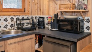 Una cocina con estufa, cafetera, microondas y pileta.