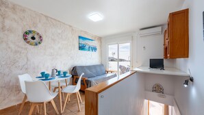 A compact living space with a kitchenette, dining area, and a sofa.