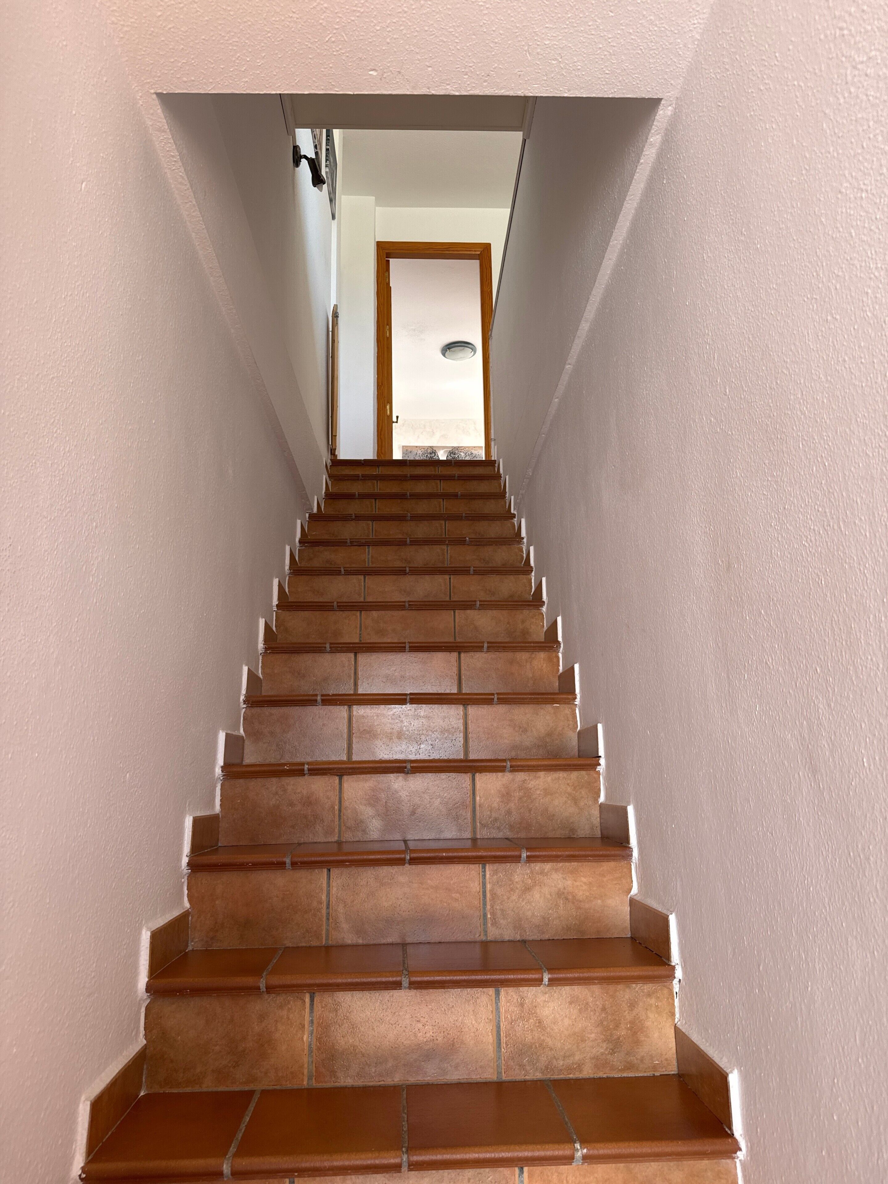 Una escalera con barandilla que conduce a un espacio interior.