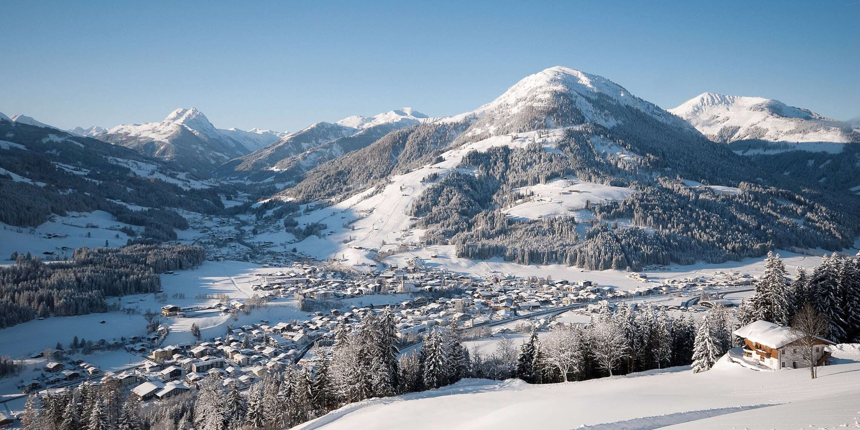 A snow-covered mountain town with buildings and trees.