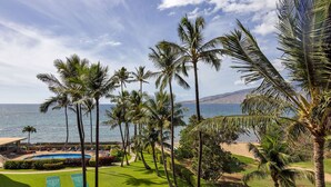 Ein Resort mit Pool, Shuffleboardplätzen und Palmen, das auf den Ozean blickt.