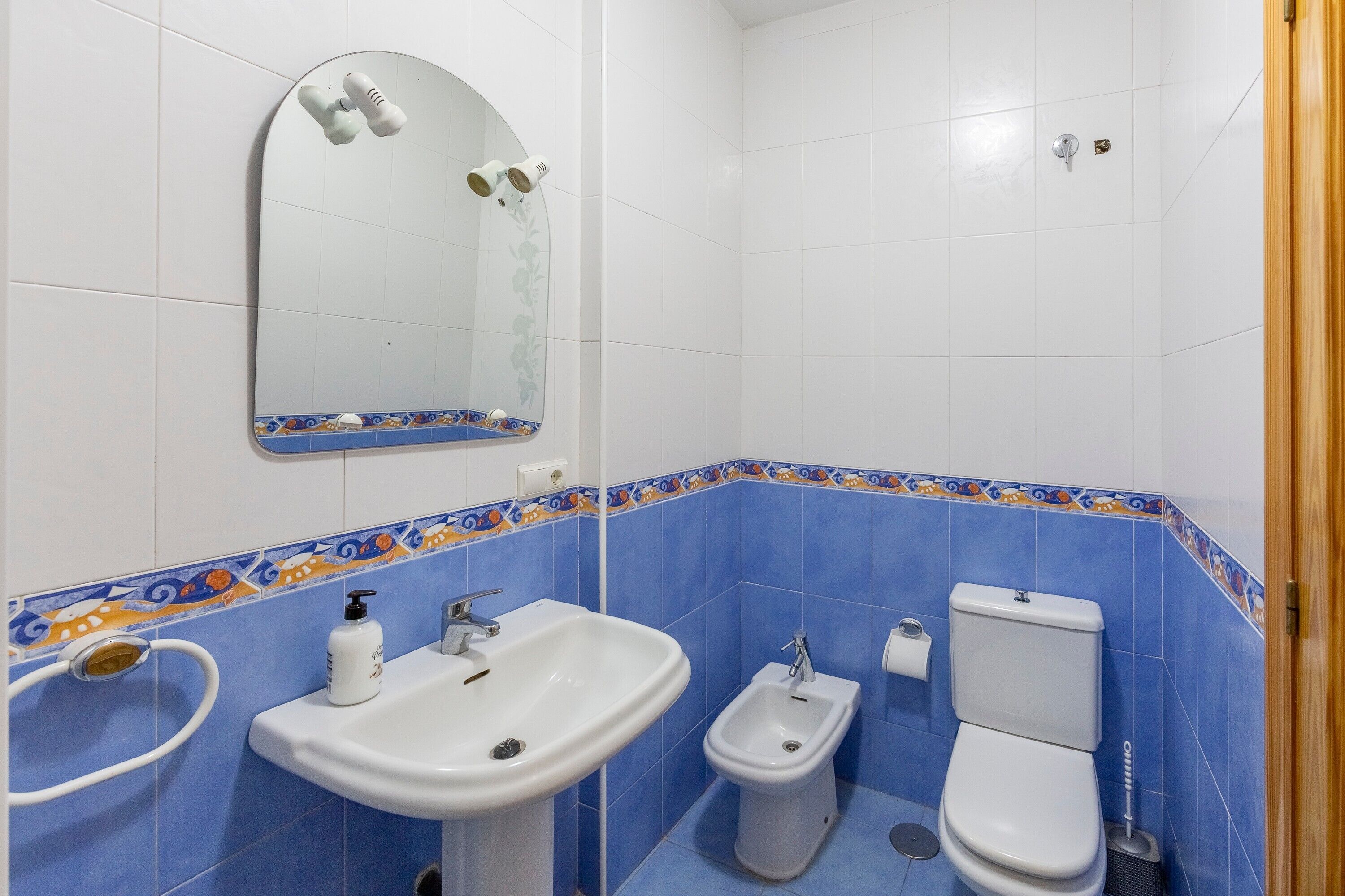 Un baño con lavabo, bidé, inodoro y espejo.