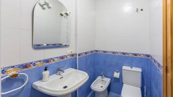 Un baño con lavabo, bidé, inodoro y espejo.