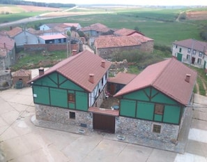 Il s’agit d’un bâtiment traditionnel, avec une base en pierre et des murs supérieurs peints en vert, un toit recouvert de tuiles rouges et une petite entrée à l’avant.