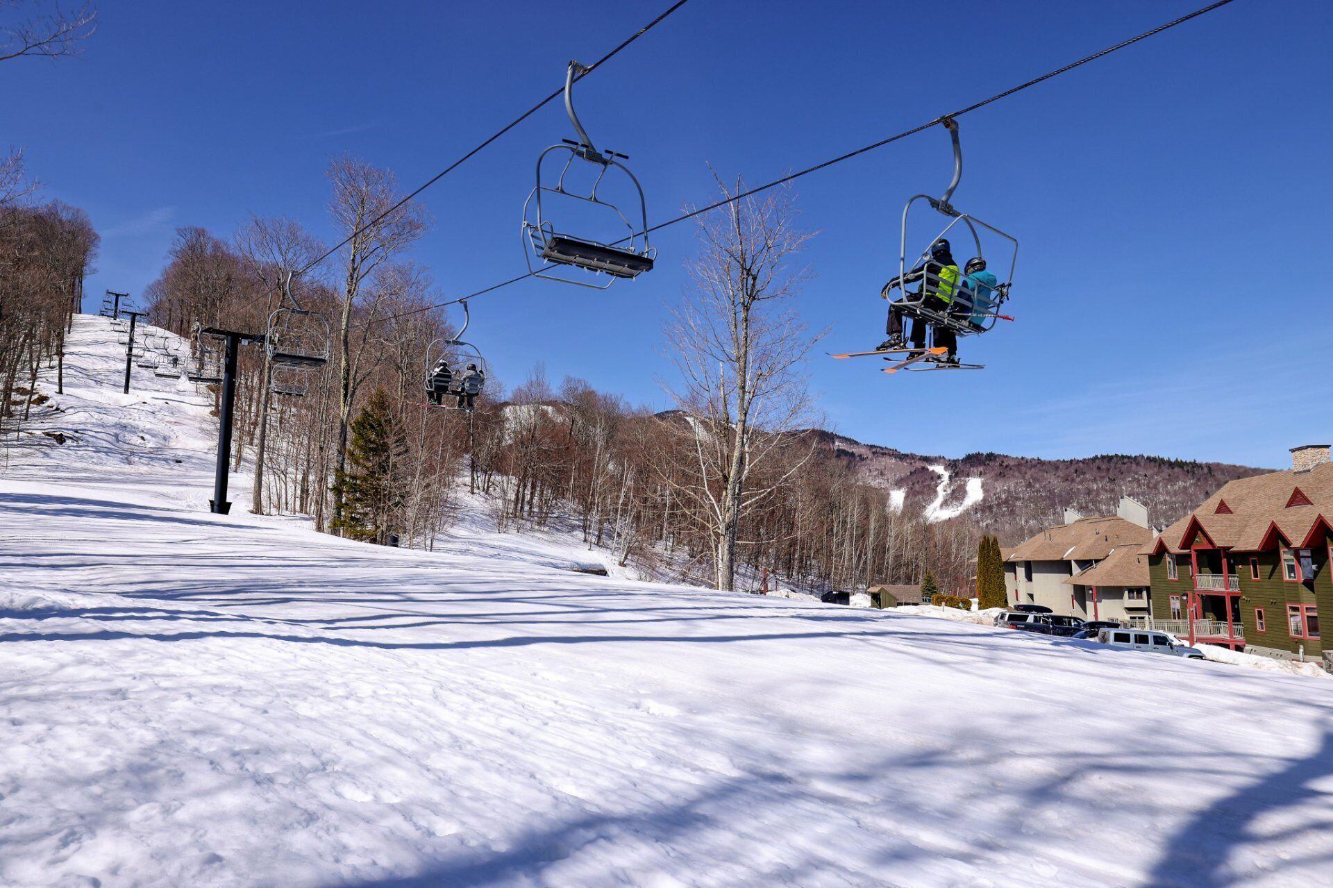 A ski lift with skiers and a snow-covered slope.