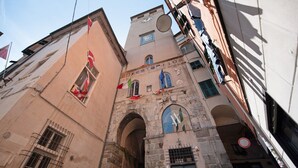 A historic building with a clock tower, arched windows, and a green door.