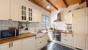 A kitchen with white cabinets, a microwave, a sink, and a stove.