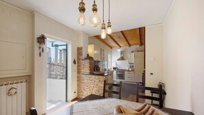 A dining area with a table, chairs, and hanging light fixtures.