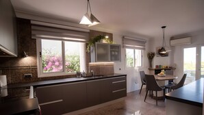 A modern kitchen with a central island, granite countertops, and pendant lighting.