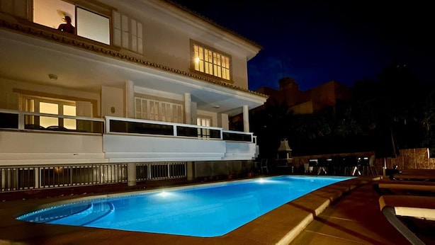 A swimming pool with a white building in the background.