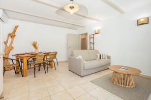 Ein modernes Wohnzimmer mit Essbereich, einer Couch, einem Couchtisch und einer einzigartigen Holzskulptur.
