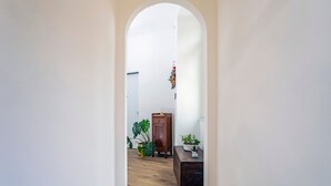 A hallway with a wooden floor, a wooden cabinet, and potted plants. - Room 'Angelica' with Wi-Fi and Air Conditioning (Catania)