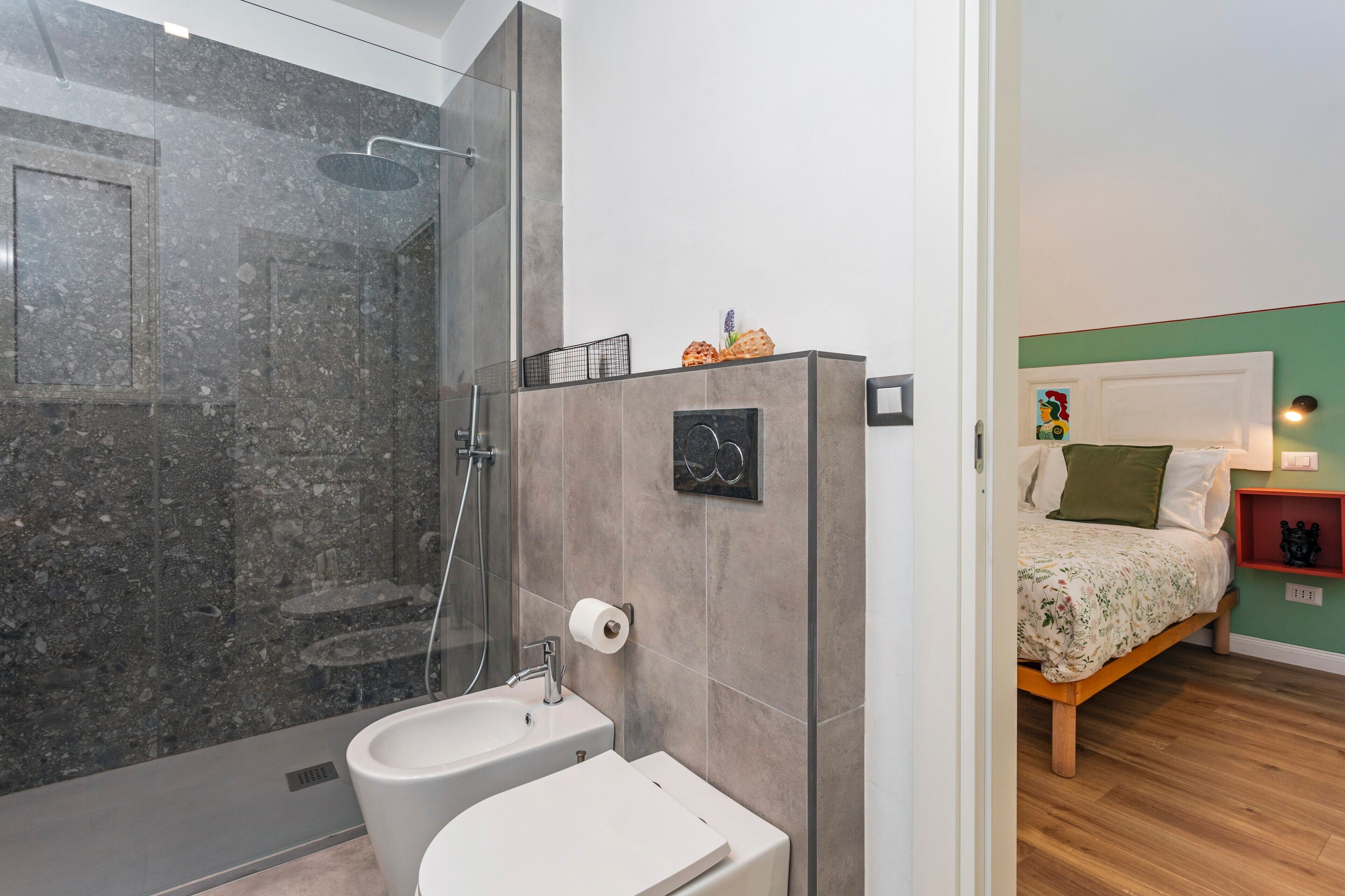 Een moderne badkamer met een douche, toilet en wastafel.