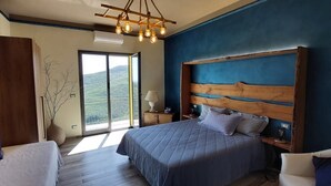 Un dormitorio con una cama grande, cabecera de madera, mesita de noche, lámpara y vistas al exterior.