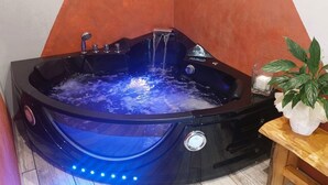 Un jacuzzi con chorros de agua, un panel de control y una planta en maceta.
