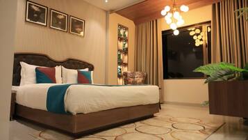 A neatly made bed with a wooden headboard, a decorative wall panel, and a hanging light fixture.