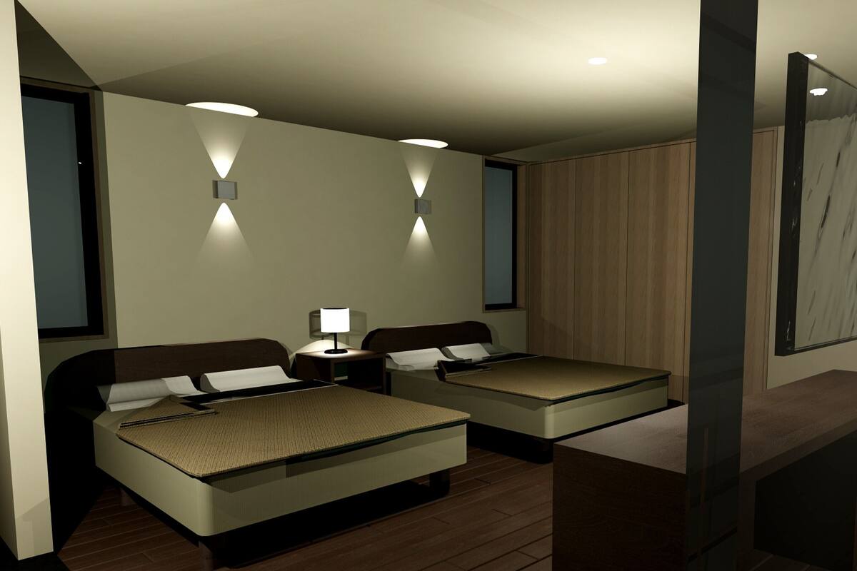 A hotel room with two beds, bedside tables, a desk, and a large mirror.