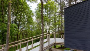 A wooden staircase leading to a building surrounded by trees. - Chalet 'La Cafoutche De Minus Renovated' with Private Terrace, Shared Garden & Wi-Fi (Gommenec'h)