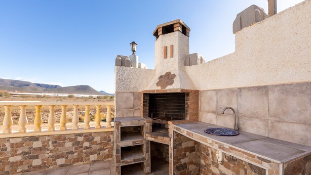 An outdoor kitchen with a stone counter, a built-in grill, and a view of the mountains. - Holiday Home 'La Tierra' with Private Terrace (Nijar)
