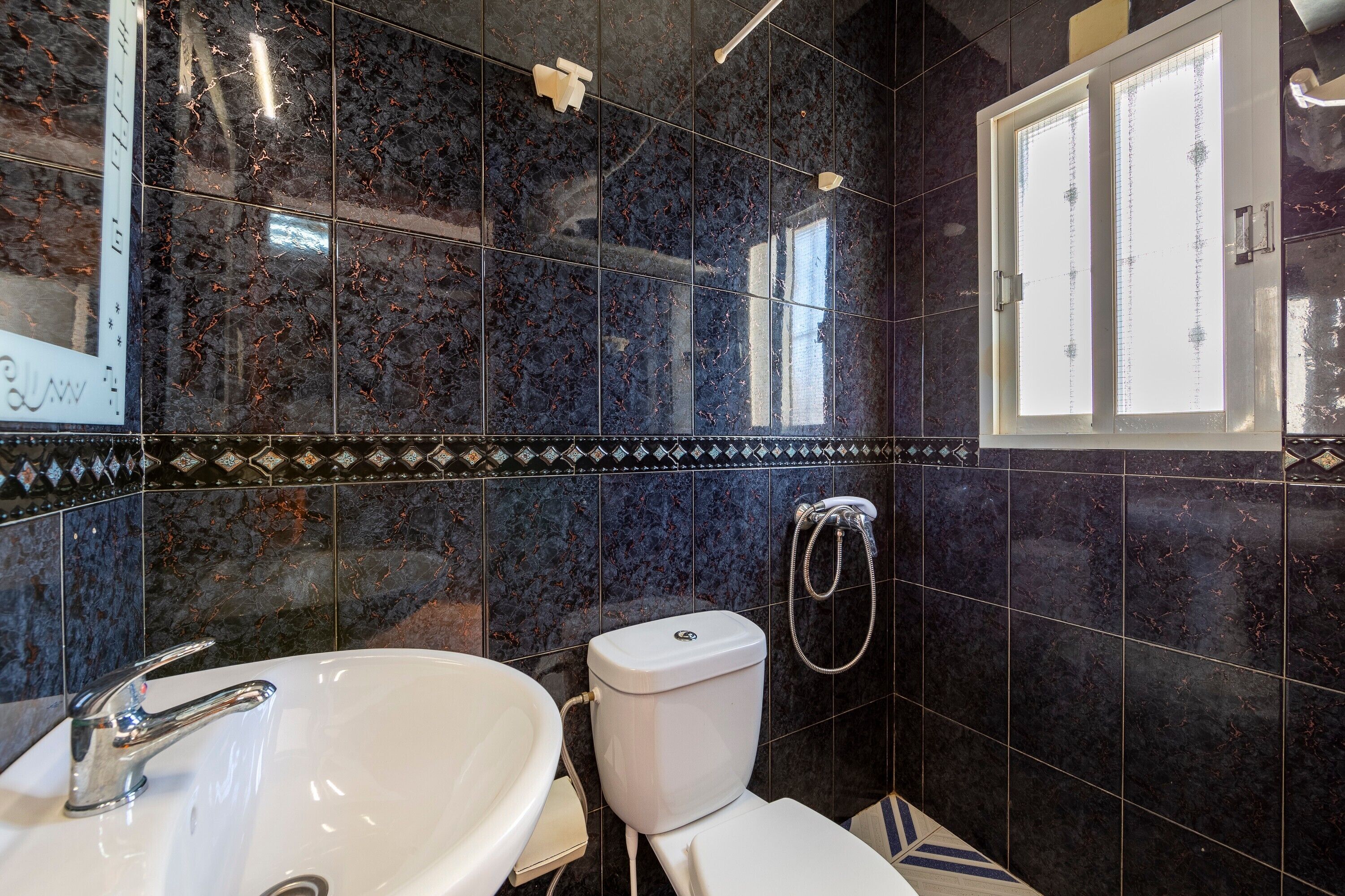 Un baño con lavamanos blanco, inodoro y ducha.