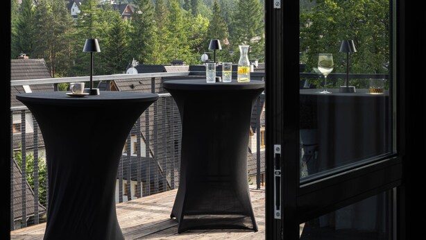 A balcony with tables and chairs, overlooking a mountainous landscape. - Hotel Rzemieślnik Zakopane  (Zakopane)