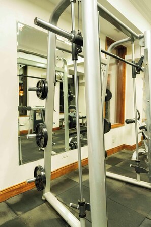 A gym with weightlifting equipment, mirrors, and a wooden floor. - Gem Suites Hotel & Luxury Serviced Apartments (Nairobi)
