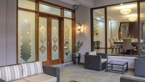 Un vaste espace extérieur aménagé avec des meubles en osier et une table basse à plateau en verre.