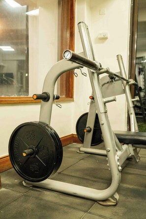 Máquina de levantamiento de pesas con discos ajustables en un gimnasio.