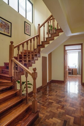 A wooden staircase with a handrail, leading to a room with a desk and chair. - Gem Suites Hotel & Luxury Serviced Apartments (Nairobi)