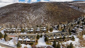 A resort with multiple buildings, a road, and a snow-covered landscape. - Newly furnished with private hot tub in Prospector community (Park City)