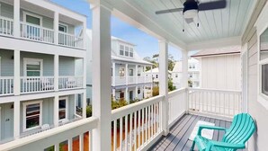 A multi-story building with a balcony, a ceiling fan, and a turquoise chair. - Golf Cart ☀️ 6 Seat Cart thru 10/31, 3 Min to Beach, Foosball, Pool ☀️ Dune Allen (Santa Rosa Beach)