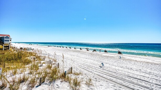 A beach with a building on the left, clear skies, and the ocean in the background. - Golf Cart ☀️ 6 Seat Cart thru 10/31, 3 Min to Beach, Foosball, Pool ☀️ Dune Allen (Santa Rosa Beach)