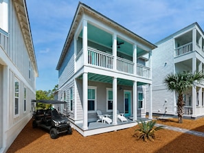 A two-story house with a balcony, a golf cart, and a small palm tree. - ☀️ New Rental, 6 Seat Golf Cart, Off 30A, 3 Min to Beach, Comm Pool, Foosball ☀️ (Santa Rosa Beach)