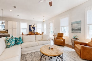 A spacious living room with a sofa, armchairs, a coffee table, and a dining area with a table and chairs. - ☀️ New Rental, 6 Seat Golf Cart, Off 30A, 3 Min to Beach, Comm Pool, Foosball ☀️ (Santa Rosa Beach)