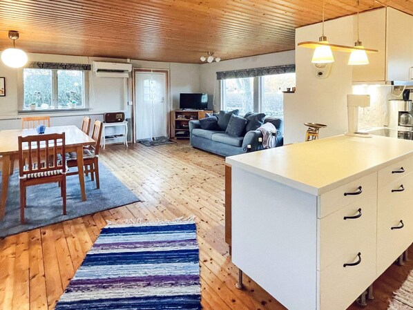 A cozy living space with a dining area, a sofa, and a kitchen.