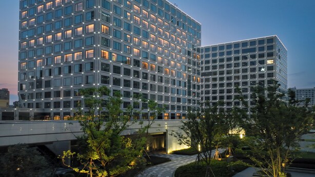 A modern hotel with a prominent "Pagoda" sign, featuring a grid of windows and a well-lit facade. - Pagoda Hotel Hangzhou Zijingang - Near Zhejiang University and Xixi National Wetland Area (Hangzhou)