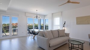 A spacious living room with a sofa, a glass coffee table, and a dining area with chairs and a table. - Ref. 493728 (Motril)