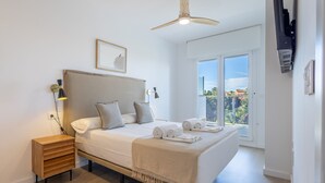 A bedroom with a bed, bedside table, lamp, ceiling fan, and a view through the window. - Ref. 493728 (Motril)