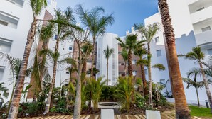 A modern building with multiple floors, surrounded by palm trees and a small water feature. - Ref. 502550 (Motril)