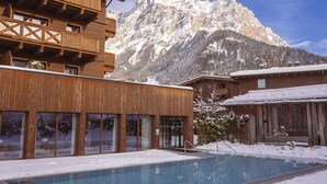 A wooden building with a pool in front, surrounded by snow-covered mountains. - Beautiful Chalet With Swimming Pool (Ehrwald)